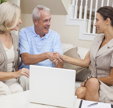 Conseiller expliquant à une famille les coûts et options de financement des maisons de repos et maisons de soins en Belgique.